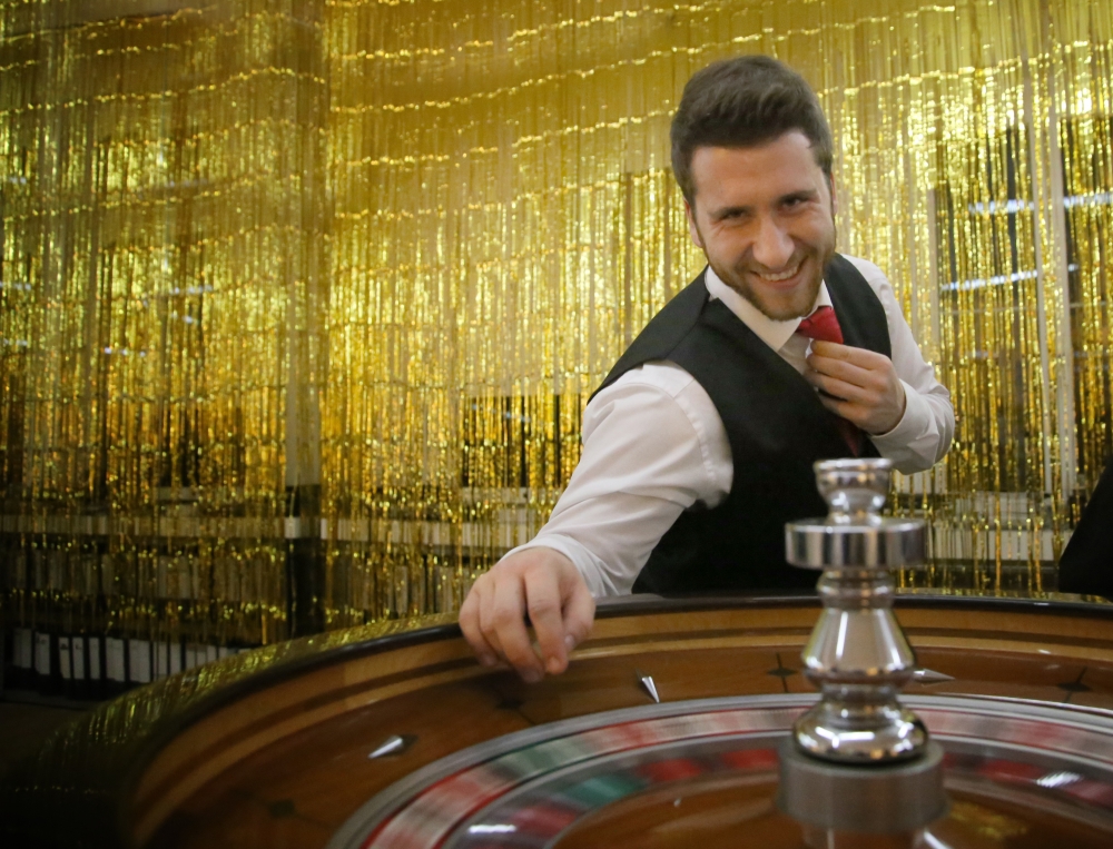 Roulette Croupier vor goldenem Vorhang